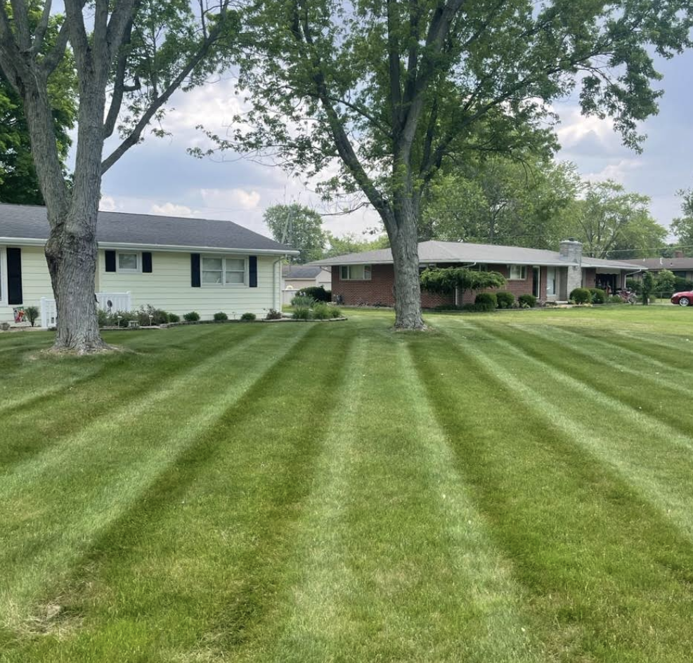 Two neighboring Lima Ohio homes with crisply striped, freshly mowed lawns